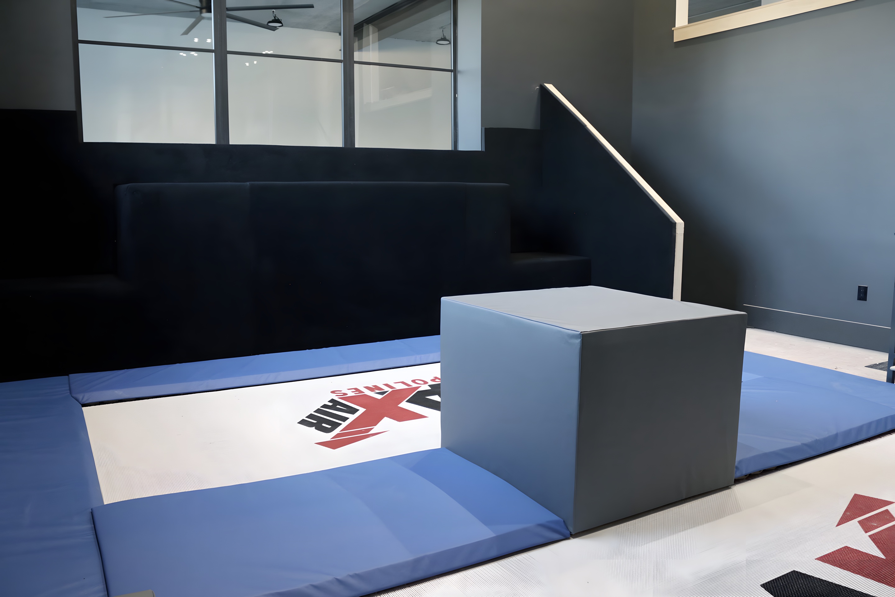 A finished home trampoline room with a MaxAir bed, padded custom jumping block and padded steps